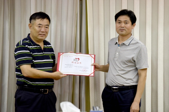 圖為臨泉縣教育局局長柳洪明（右）為湖南東健藥業(yè)有限公司頒發(fā)捐贈(zèng)證書。記者蔣守福 攝.jpg